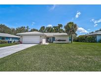 Charming single-story home with a well-manicured lawn and a classic white tiled roof at 903 E Shannon Ct, Venice, FL 34293