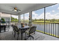 Screened lanai featuring a ceiling fan, outdoor dining set, and lovely views of the water at 935 Tidewater Shores # 721, Bradenton, FL 34208