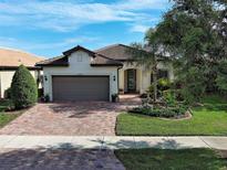 Charming single-story home featuring a brick driveway, two-car garage, and well-manicured landscaping at 13862 Miranese St, Venice, FL 34293