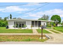 Charming single-story home featuring a well-maintained lawn, carport, and neutral exterior paint at 6111 Talbot St, North Port, FL 34287