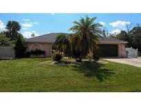 Single-story home with a two-car garage and lawn at 18245 Ackerman Ave, Port Charlotte, FL 33948