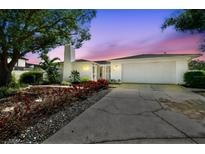 Charming single-story home with a two-car garage, white brick, and beautiful landscaping at 7405 Clearview Dr, Tampa, FL 33634