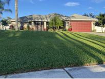 Single story home with red garage door at 4023 Platt St, North Port, FL 34286