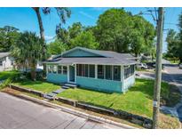 Charming bungalow with a light blue exterior, screened porch, and well-maintained lawn at 922 E Ida St, Tampa, FL 33603