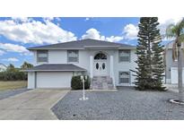 Charming two-story home boasts a well-manicured front yard, a two car garage, and lovely curb appeal at 7438 Gulf Way, Hudson, FL 34667