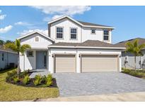 Charming two-story home with a three car garage and well-manicured landscaping at 9589 Vibrant Lane, Venice, FL 34292