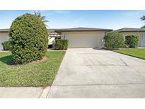 Charming home featuring a two-car garage, well-maintained landscaping, and a concrete driveway at 7483 Carnoustie Dr # 5B, Sarasota, FL 34238