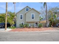 Charming two-story house with brick pavers and a lush, tropical landscape at 117 88Th Ave, Treasure Island, FL 33706