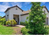 Single-story home with attractive landscaping and a covered entryway at 11145 Mc Dermott Ct, Englewood, FL 34223