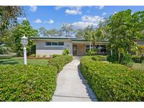 Charming single-story home featuring a well-manicured lawn and welcoming walkway leading to the front door at 3240 San Mateo St, Clearwater, FL 33759