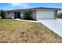 Single-story home with attached garage and landscaped yard at 9308 San Bernandino Ave, Englewood, FL 34224