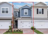 Charming two-story townhome with a brick driveway, attached garage, and professionally landscaped front yard at 17339 Peregrine Way, Punta Gorda, FL 33982