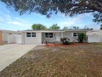 Updated single-story home with a landscaped lawn and driveway at 4104 W Gray St, Tampa, FL 33609