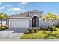 Charming one-story home with a well-manicured lawn, paver driveway, and welcoming entryway at 9584 Vibrant Lane, Venice, FL 34292