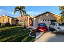 Exterior of a single-story home with a two-car garage at 4202 Perch Cir, Port Charlotte, FL 33948