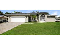 One-story house with a spacious lawn and attached garage at 1090 Yarmouth St, Port Charlotte, FL 33952