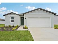 Charming single-Gathering home featuring a well-manicured lawn, green front door, and two-car garage at 145 Lazy Shore Dr, Nokomis, FL 34275
