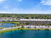 Aerial view of an apartment building beside a tranquil lake at 6400 46Th N Ave # 102, Kenneth City, FL 33709