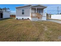 Charming single-story home with a welcoming front porch and landscaped yard at 1386 Ibis Dr, Englewood, FL 34224