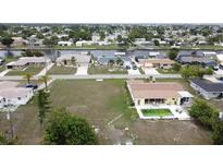 Aerial view showing home, pool, and canal-front lot at 156 Francis Ne Dr, Port Charlotte, FL 33952