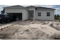 Newly built home with attached garage and unfinished landscaping at 63 Coxswaine Cir, Placida, FL 33946