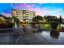Exterior view of a condo building at dusk with parking lot and landscaping at 6219 Palma Del Mar S Blvd # 301, St Petersburg, FL 33715