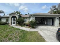 Single-story house with a two-car garage and landscaping at 4495 Amari Rd, North Port, FL 34291