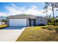 Charming one-story home with a large driveway and well-maintained lawn at 18059 Regan Ave, Port Charlotte, FL 33948
