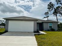 Newly constructed gray home with a two-car garage at 18059 Regan Ave, Port Charlotte, FL 33948