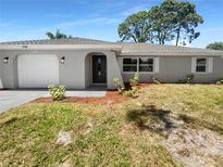 Newly renovated home with gray exterior and landscaping at 1340 Redstart Rd, Venice, FL 34293