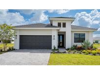 Modern single-story home with dark gray garage door and landscaping at 4845 Carova Way, Lakewood Ranch, FL 34211