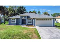 Newly constructed home with a two-car garage and well-manicured lawn at 2863 Tishman Ave, North Port, FL 34286