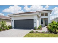 Modern one-story home with gray garage door and walkway at 18324 Rockport Pl, Lakewood Ranch, FL 34211