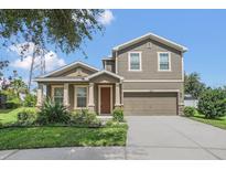 Two story house with a large garage and manicured lawn at 12302 Fairlawn Dr, Riverview, FL 33579