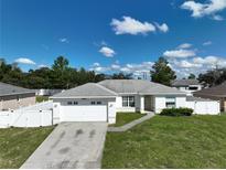 One-story home with white exterior, two-car garage, and landscaped lawn at 10255 Norwick St, Spring Hill, FL 34608