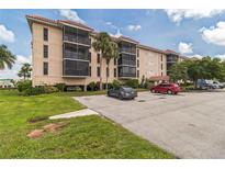 Two-story condo building with balconies, parking, and landscaping at 25188 Marion Ave # A103, Punta Gorda, FL 33950