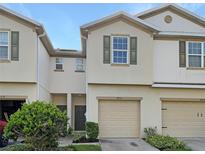 Two-story townhome with tan siding and two-car garage at 4916 White Sanderling Ct, Tampa, FL 33619