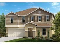Two-story home with beige siding and three-car garage at 37496 Williamette Way, Zephyrhills, FL 33540