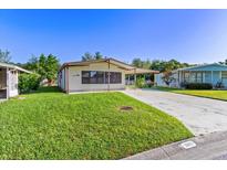 Single-wide manufactured home with carport and spacious lawn at 35935 Tanda Cir, Zephyrhills, FL 33541