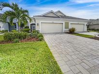 Front view of a two-car garage with paver driveway at 7615 Campus Cv, Sarasota, FL 34243
