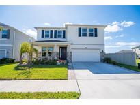 Two-story house with a white exterior and a stone facade at 8493 Hardy Bay Loop, Wesley Chapel, FL 33545