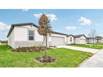 Modern one story house with gray siding and a teal door at 164 Lazy Shore Dr, Nokomis, FL 34275