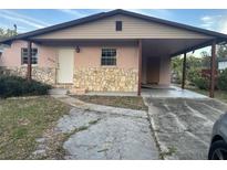 House exterior featuring a carport and stone accents at 6114 S 3Rd St, Tampa, FL 33611