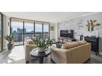 Bright living room features a stone accent wall and expansive windows with city views at 2413 Bayshore Blvd # 1404, Tampa, FL 33629