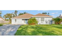 Single-story house with a gray exterior and a well-maintained lawn at 2443 Waterfall Dr, Spring Hill, FL 34608