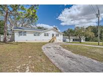 White single-story home with a gravel driveway at 11335 Pickford St, Spring Hill, FL 34609