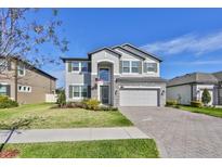 Two-story house with a large driveway and manicured lawn at 19293 Breynia Dr, Lutz, FL 33558