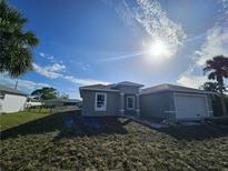 Newly built home with a two-car garage and well-maintained lawn at 22139 Lockport Ave, Port Charlotte, FL 33952