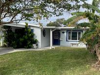 Light blue single story home with a well manicured lawn and covered entryway at 5400 Circle Dr, Weeki Wachee, FL 34607