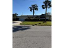 Single story home with a two-car garage and palm trees at 1007 Normandy Rd, Clearwater, FL 33764